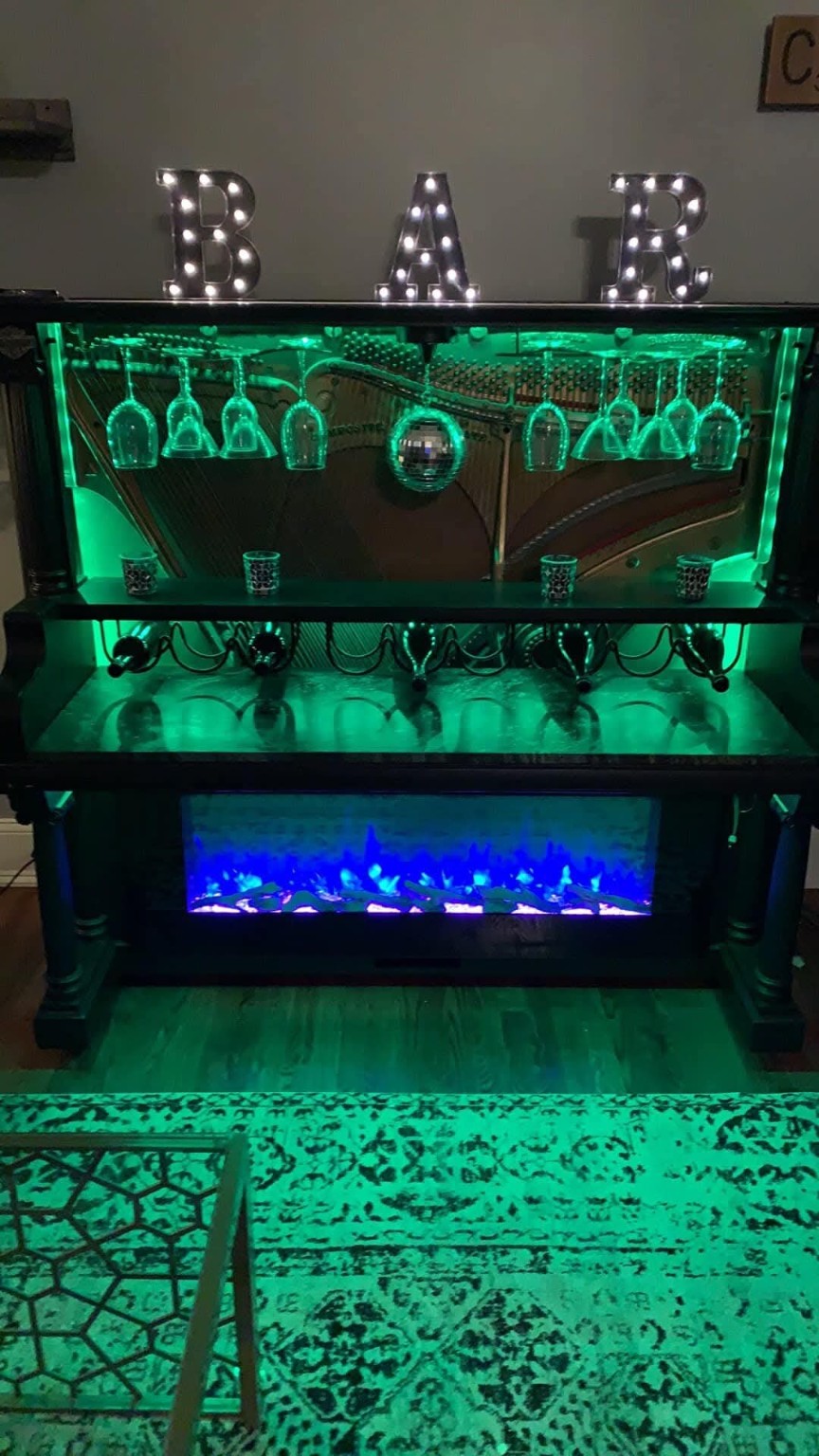 Custom piano bar illuminated with green accent lighting