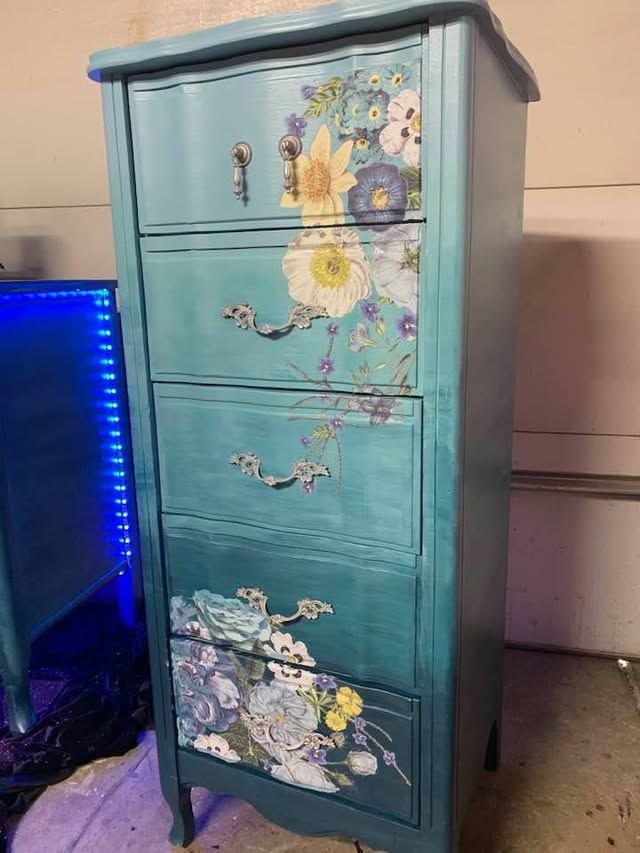 Tall teal chest with hand-painted flowers and decorative scenes