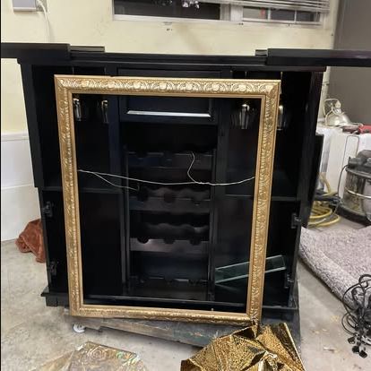 Black and gold bar cabinet during restoration