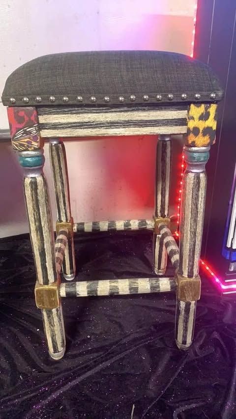 Colorfully painted upholstered stool with metallic carved legs