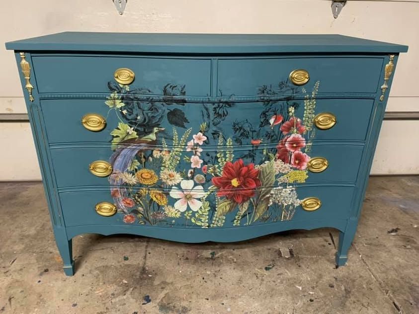 Teal dresser with a large floral design and gold hardware